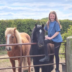 girl in blue t-shirt with horses